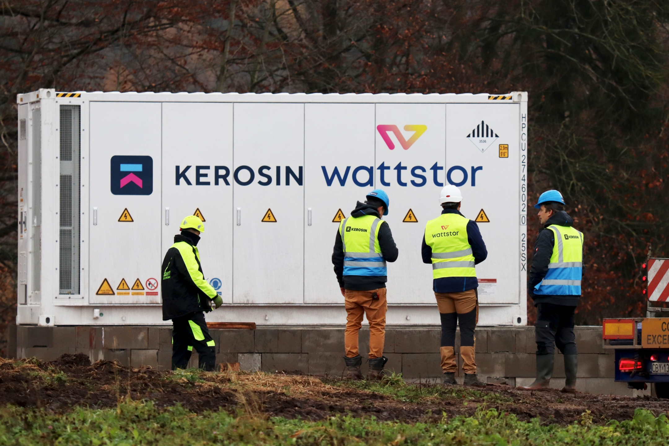 Zaměstnanci společností Wattstor a KEROSIN v ochranných vestách před bateriovým úložištěm od společnosti Wattstor.